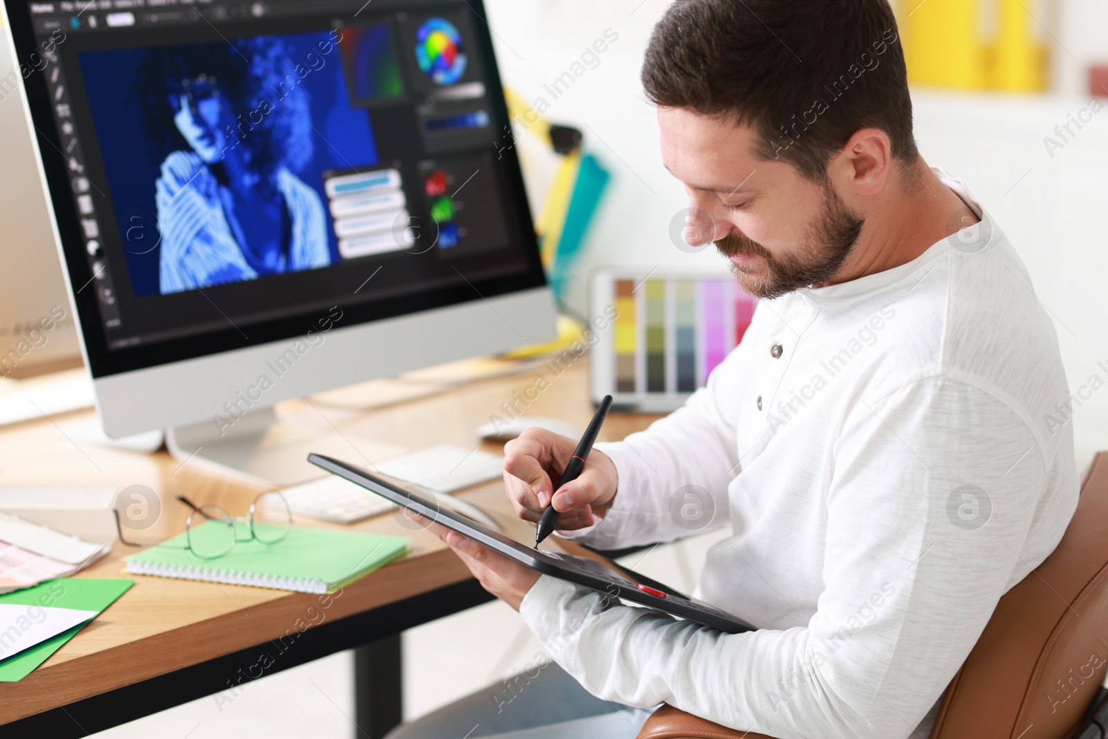 Photo of Designer working with tablet at table in office