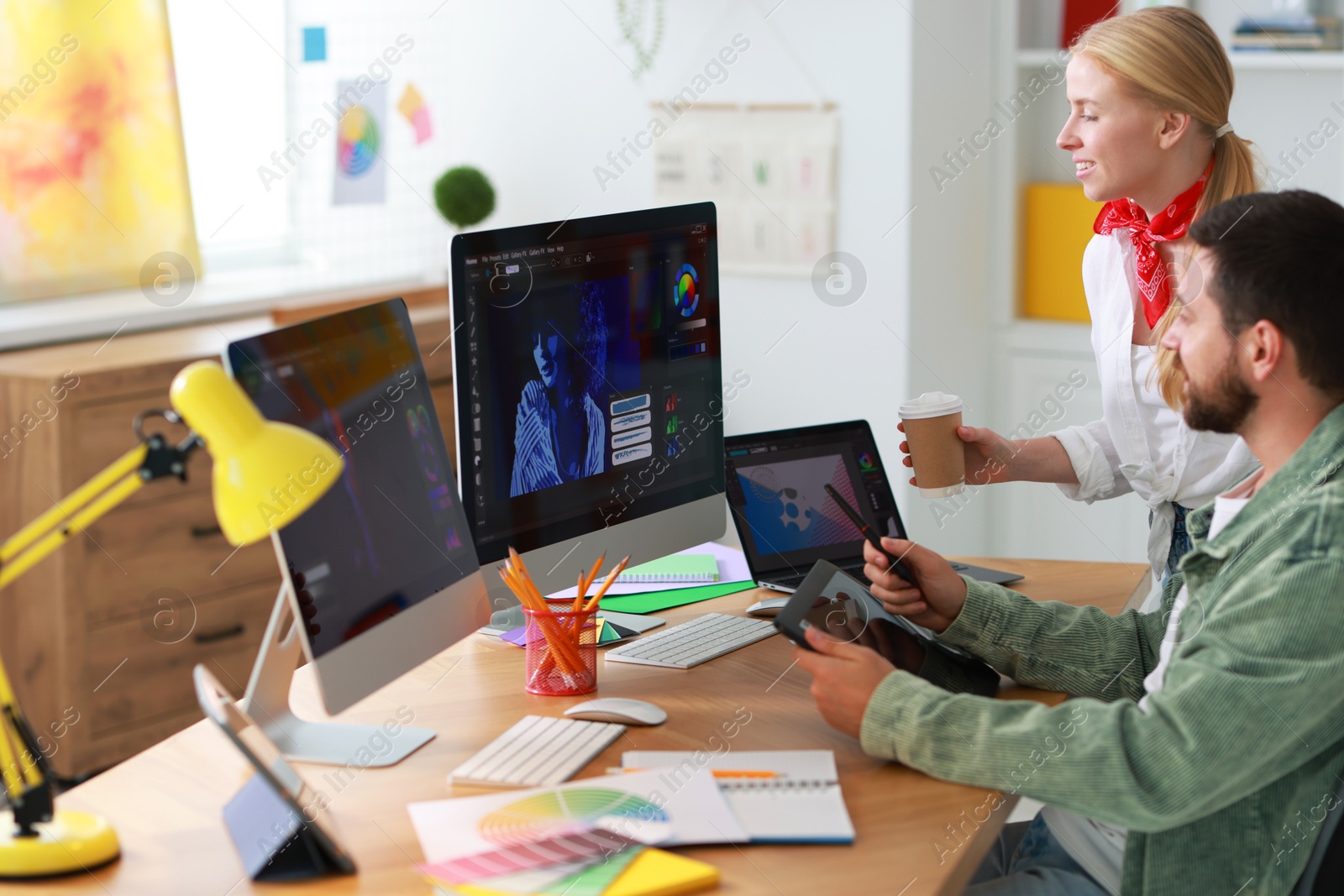 Photo of Designers working at table together in office