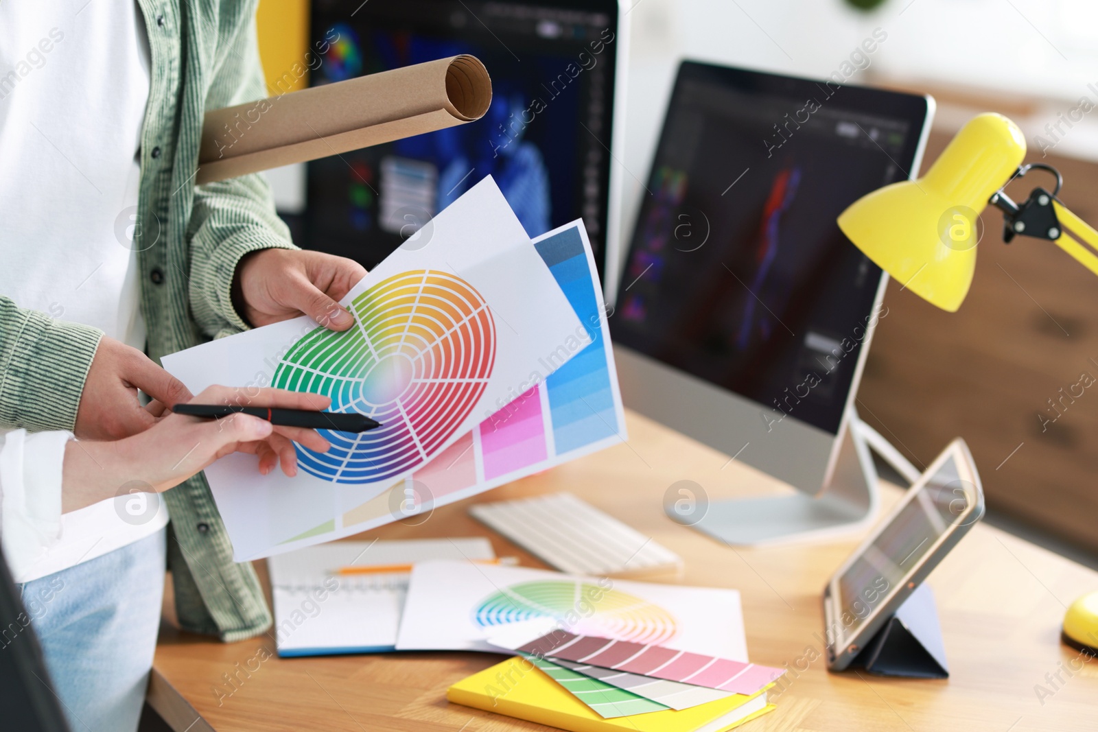 Photo of Designer with color samples working in office, closeup