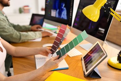 Photo of Designers working together at table in office, closeup