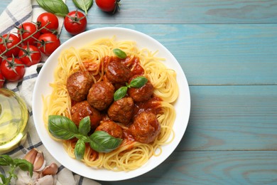 Photo of Delicious pasta with meatballs and ingredients on blue wooden table, flat lay