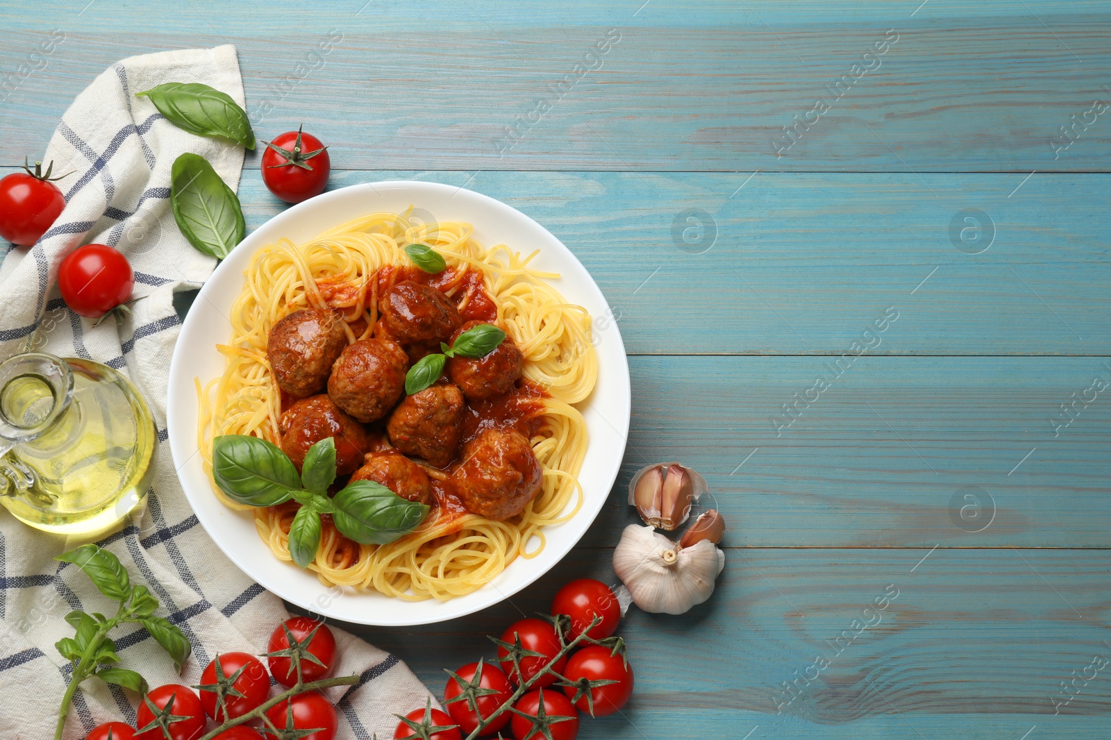 Photo of Delicious pasta with meatballs and ingredients on blue wooden table, flat lay. Space for text