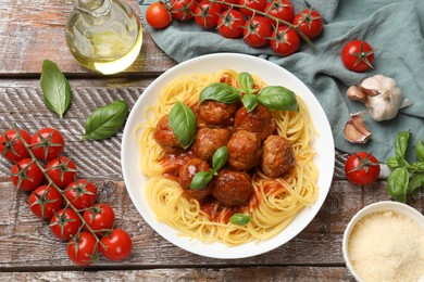 Photo of Delicious pasta with meatballs and ingredients on wooden table, flat lay