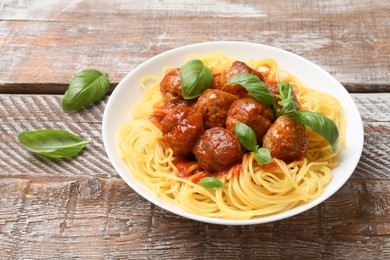 Delicious pasta with meatballs on wooden table