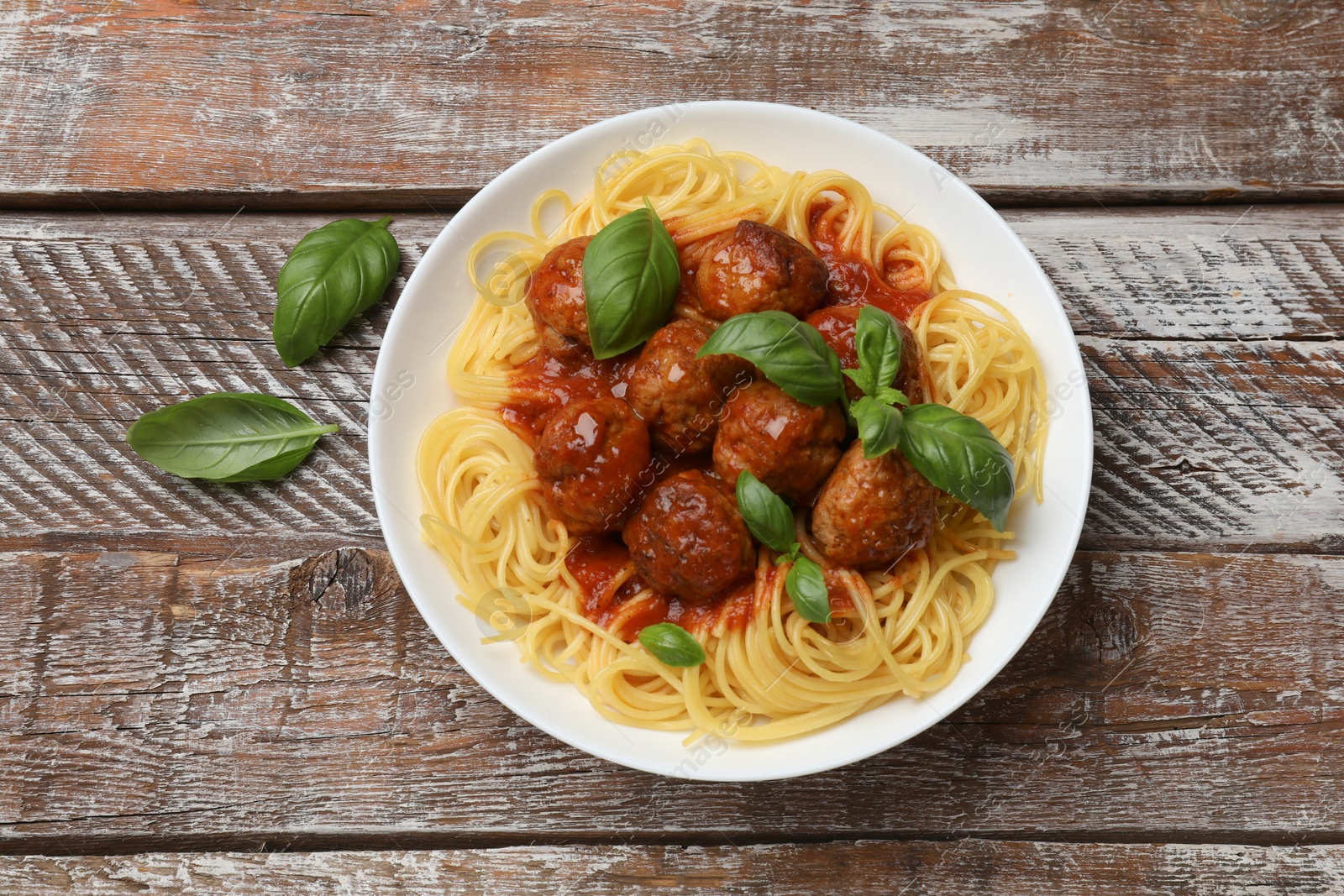 Photo of Delicious pasta with meatballs on wooden table, top view