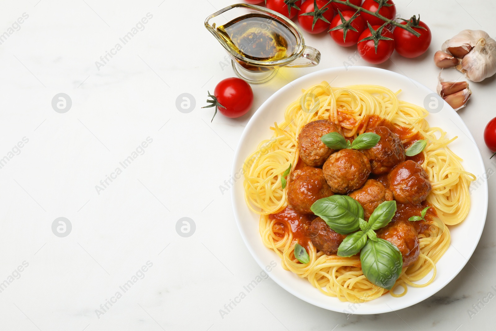 Photo of Delicious pasta with meatballs and ingredients on white marble table, flat lay. Space for text