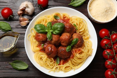 Delicious pasta with meatballs and ingredients on wooden table, flat lay