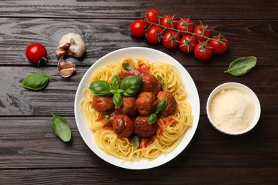 Delicious pasta with meatballs and ingredients on wooden table, flat lay