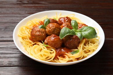 Delicious pasta with meatballs on wooden table, closeup