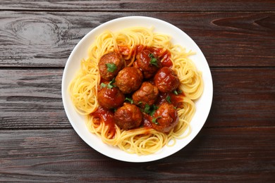 Photo of Delicious pasta with meatballs on wooden table, top view