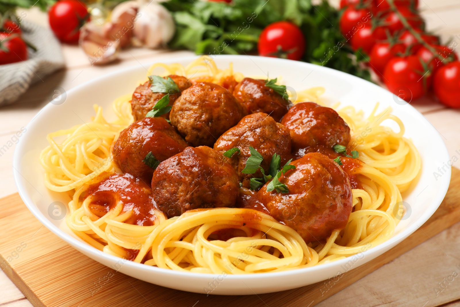 Photo of Delicious pasta with meatballs and ingredients on white wooden table, closeup