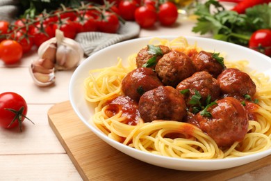 Delicious pasta with meatballs and ingredients on white wooden table, closeup