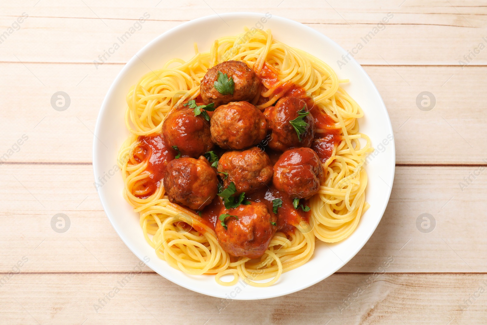 Photo of Delicious pasta with meatballs on white wooden table, top view