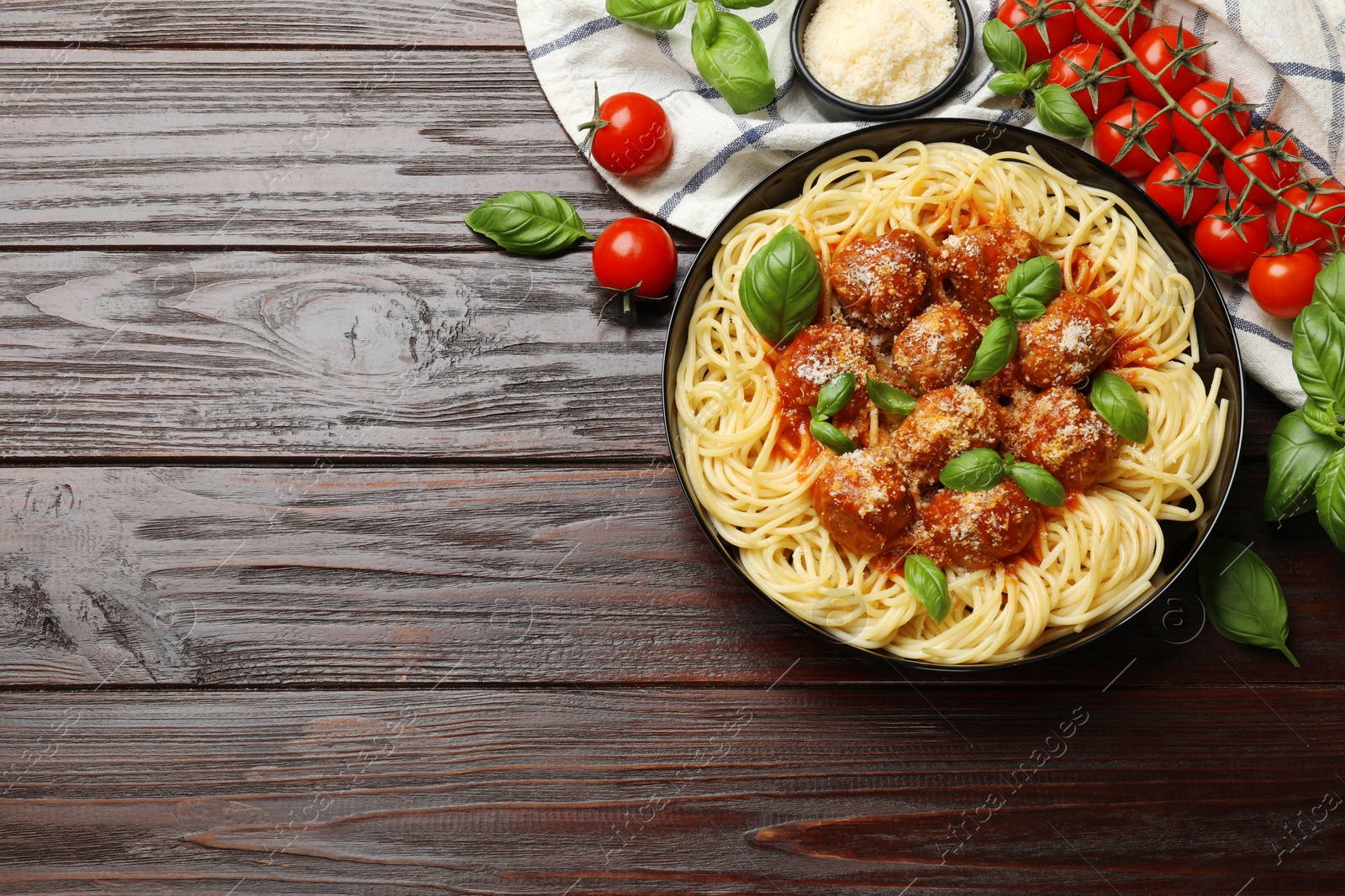 Photo of Delicious pasta with meatballs and ingredients on wooden table, flat lay. Space for text