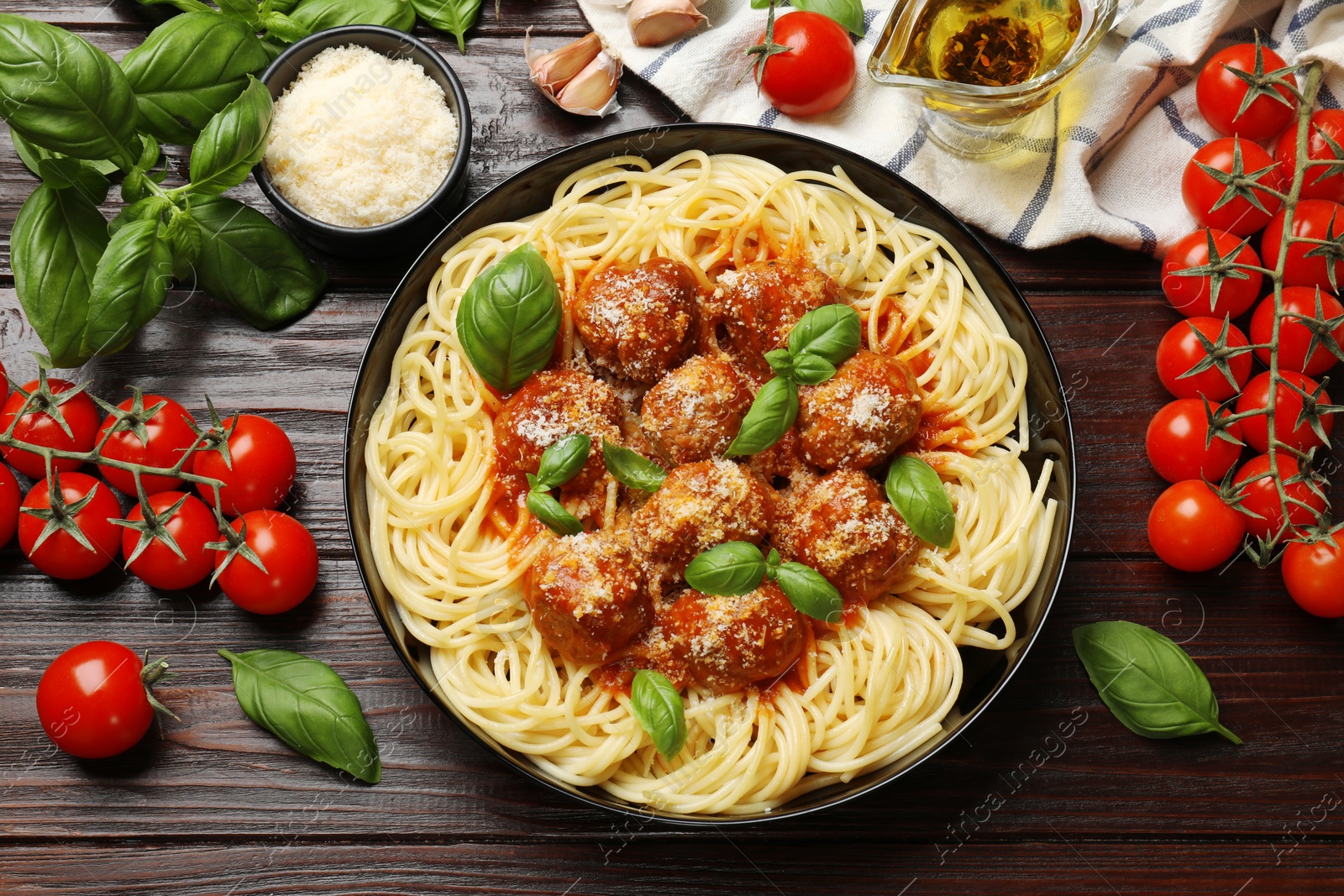 Photo of Delicious pasta with meatballs and ingredients on wooden table, flat lay