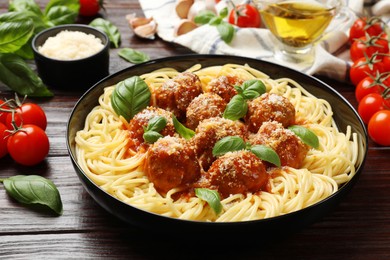 Photo of Delicious pasta with meatballs on wooden table, closeup