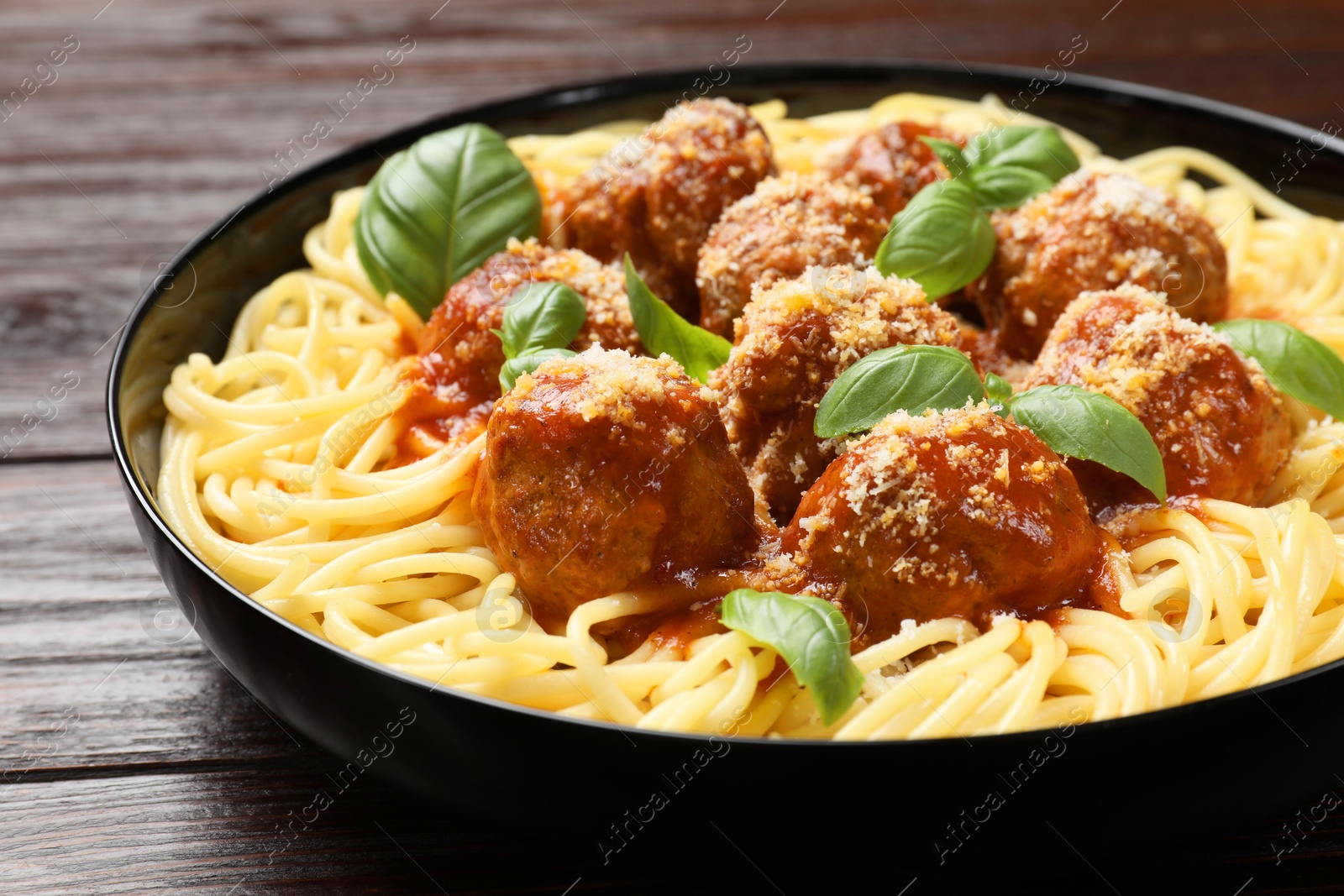 Photo of Delicious pasta with meatballs on wooden table, closeup