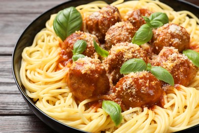 Delicious pasta with meatballs on wooden table, closeup