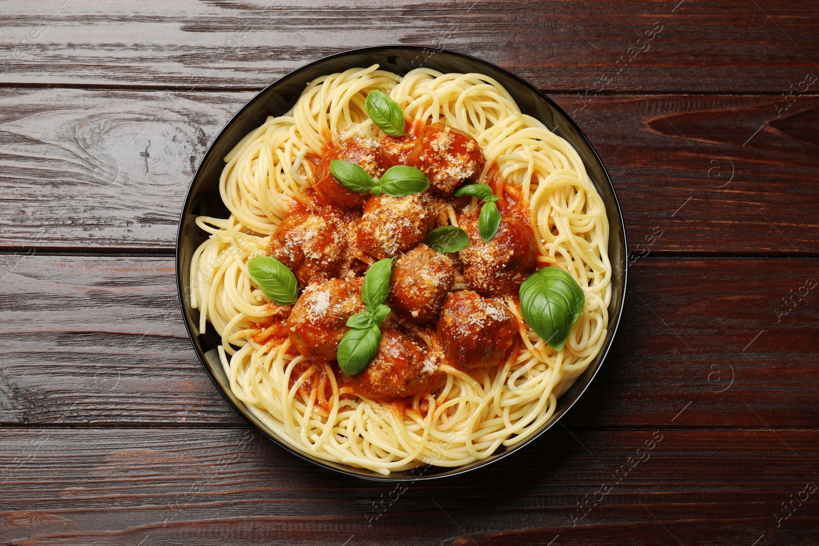 Photo of Delicious pasta with meatballs on wooden table, top view