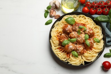 Photo of Delicious pasta with meatballs and ingredients on white marble table, flat lay. Space for text