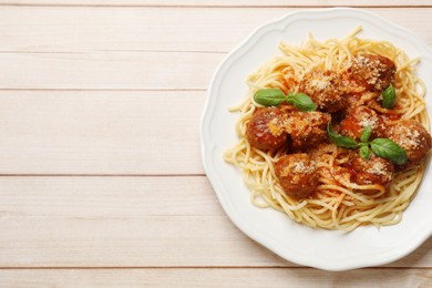 Delicious pasta with meatballs on light wooden table, top view. Space for text