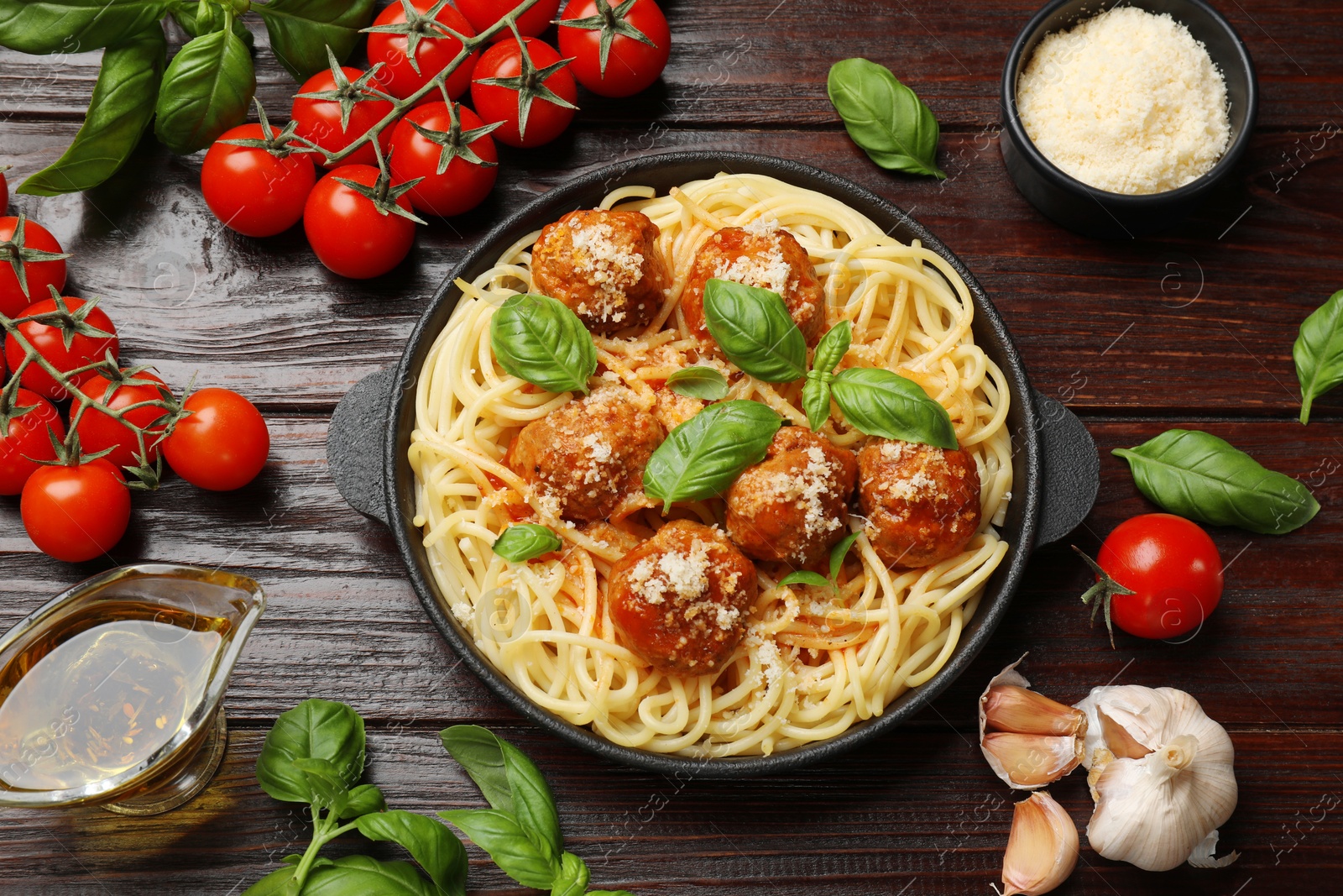 Photo of Delicious pasta with meatballs and ingredients on wooden table, flat lay