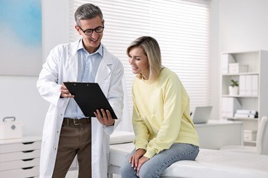 Healthcare worker with clipboard and patient in hospital