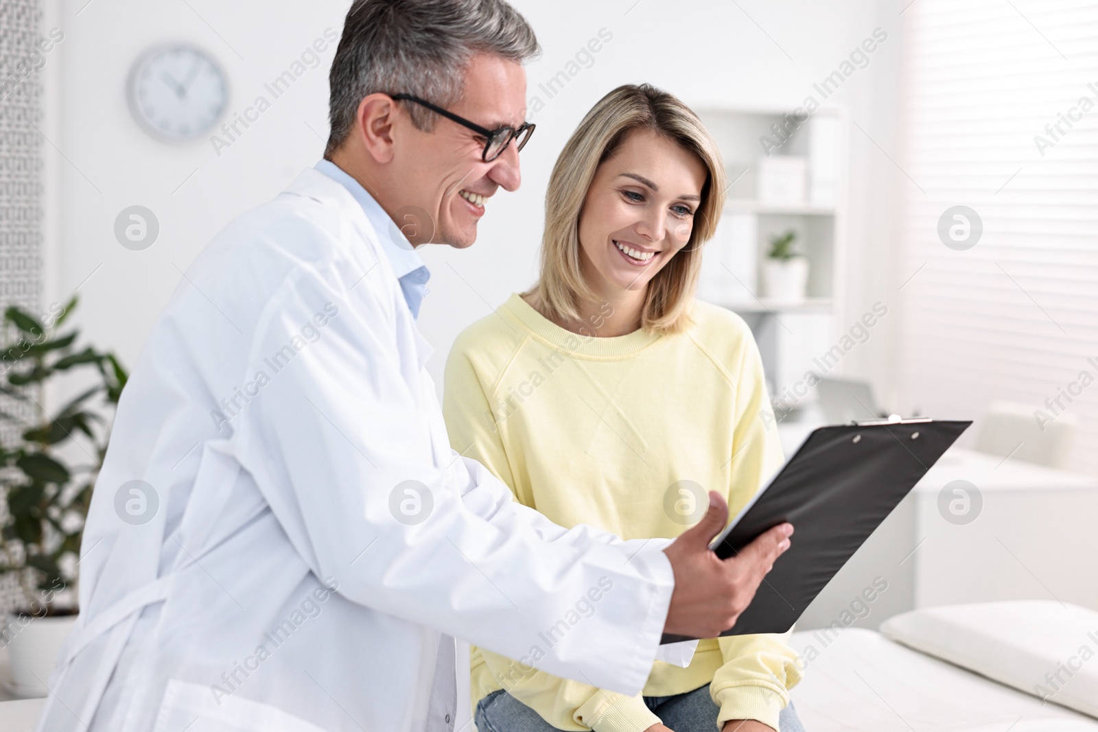 Photo of Healthcare worker with clipboard and patient in hospital