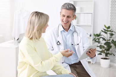 Healthcare worker with tablet and patient in hospital