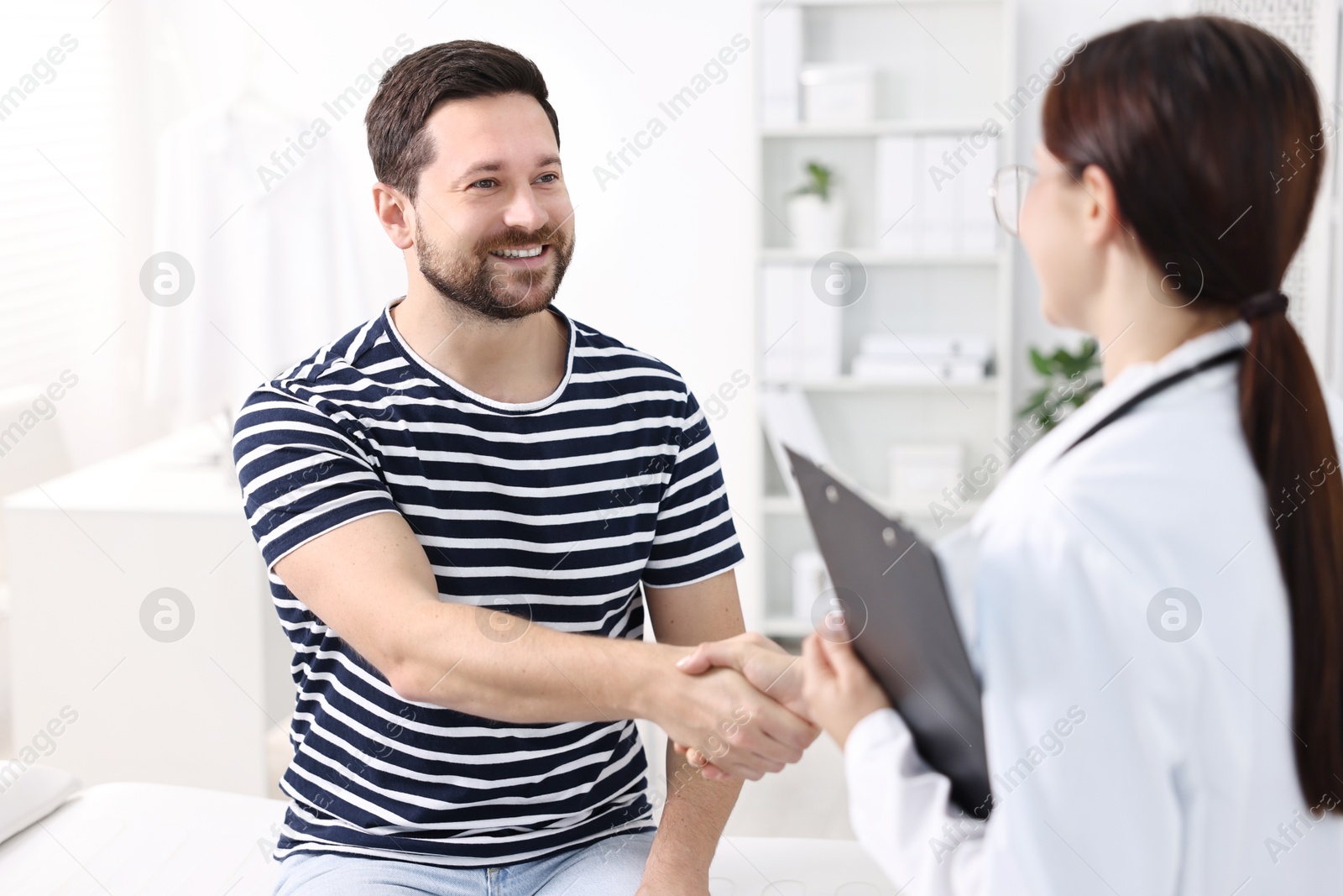 Photo of Healthcare worker shaking hands with patient in hospital