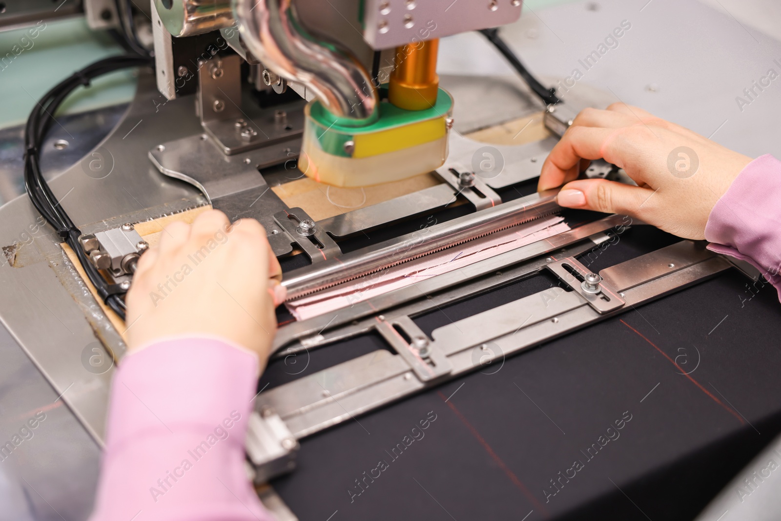 Photo of Young woman working with machine in professional workshop, closeup