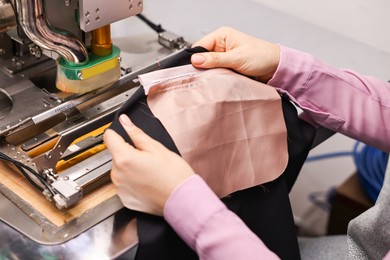 Photo of Young woman working with machine in professional workshop, closeup