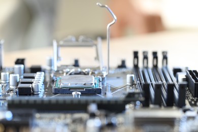 Motherboard with modern computer chip and other components on table, closeup