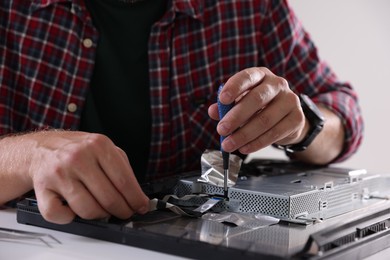 Photo of Man fixing computer monitor at white table, closeup