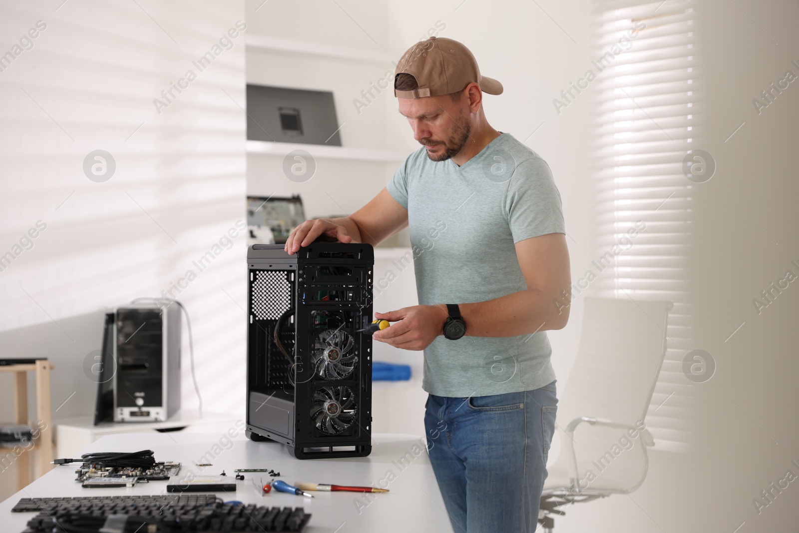 Photo of Man assembling new computer at white table