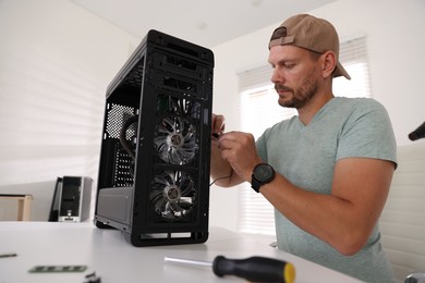 Photo of Man assembling new computer at white table