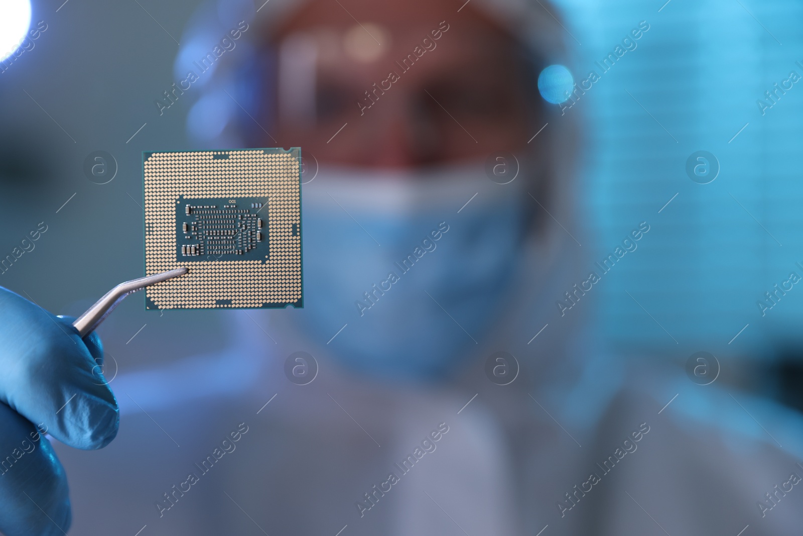 Photo of Man in mask holding computer chip on blurred background, selective focus