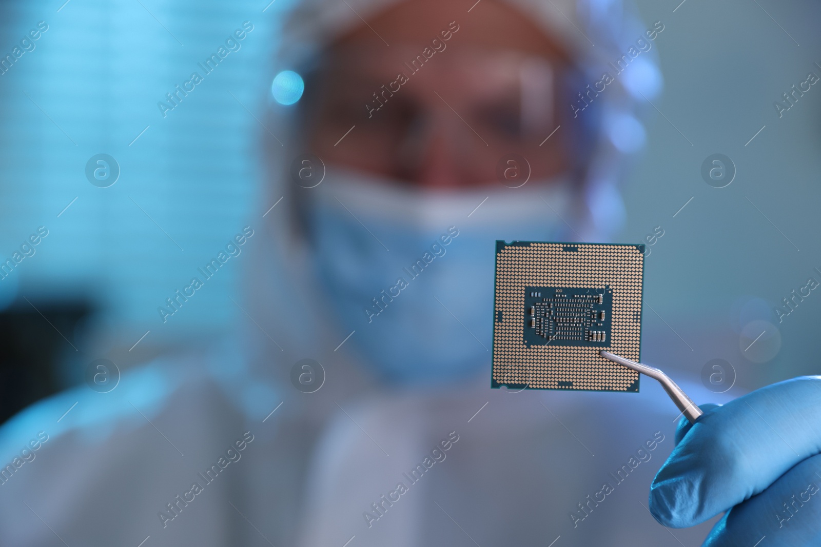 Photo of Man in mask holding computer chip on blurred background, selective focus