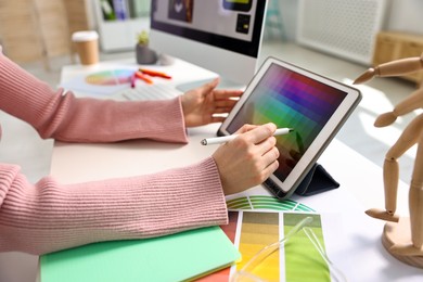 Photo of Designer working with tablet at table in office, closeup