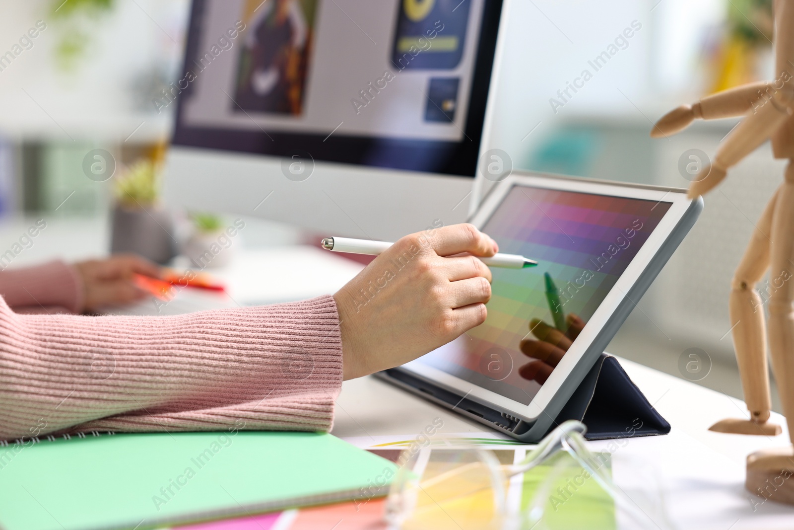 Photo of Designer working with tablet at table in office, closeup