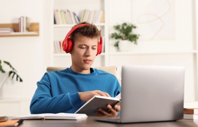 Student in headphones studying at table indoors