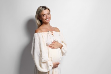 Portrait of beautiful pregnant woman on white background