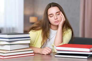 Photo of Young student with books having stress before exam at wooden table