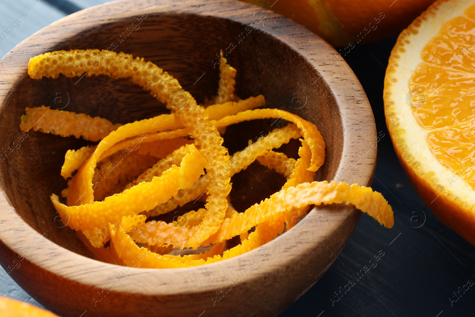 Photo of Bowl with fresh orange zest and fruits on table, closeup