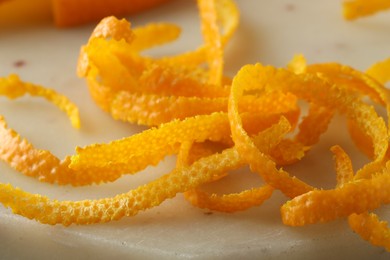 Photo of Fresh orange zest on light board, closeup