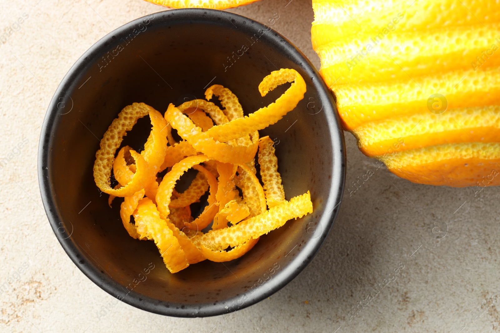 Photo of Fresh orange zest and fruit on light textured table, flat lay