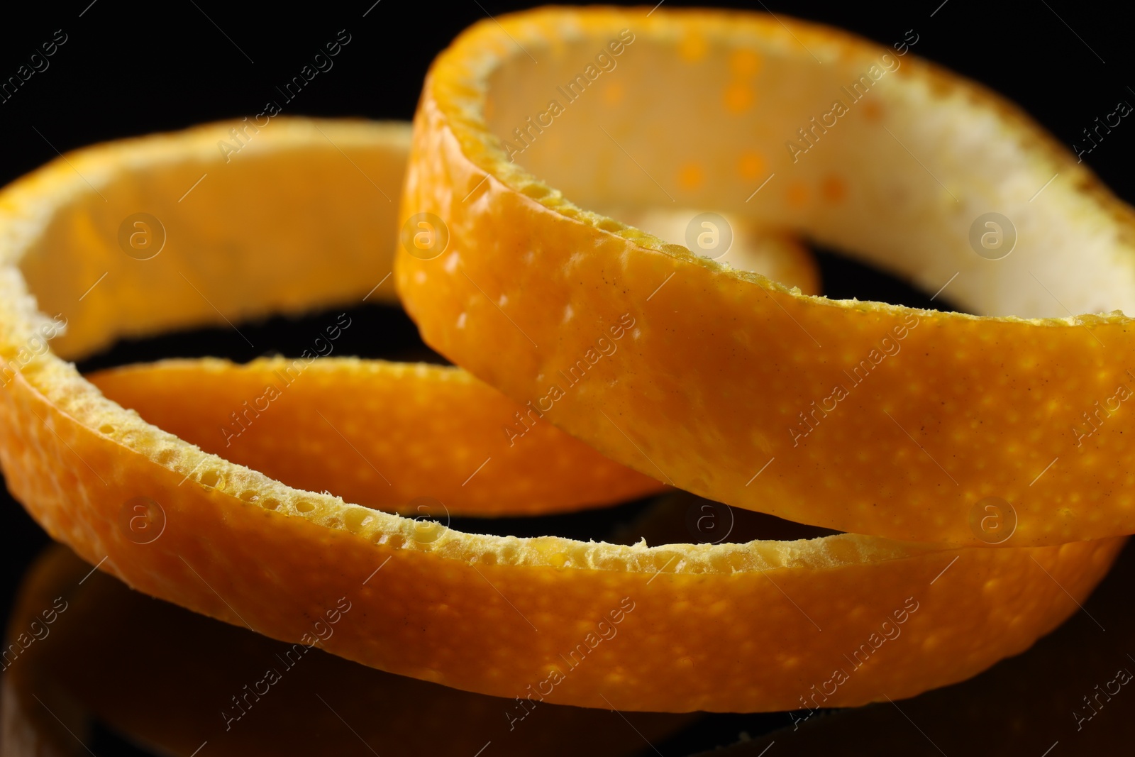 Photo of One fresh orange peel on black background, closeup