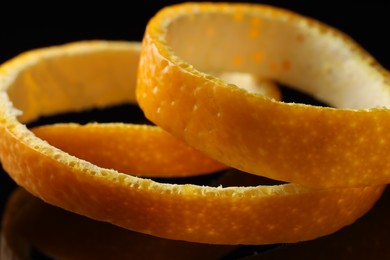 Photo of One fresh orange peel on black background, closeup