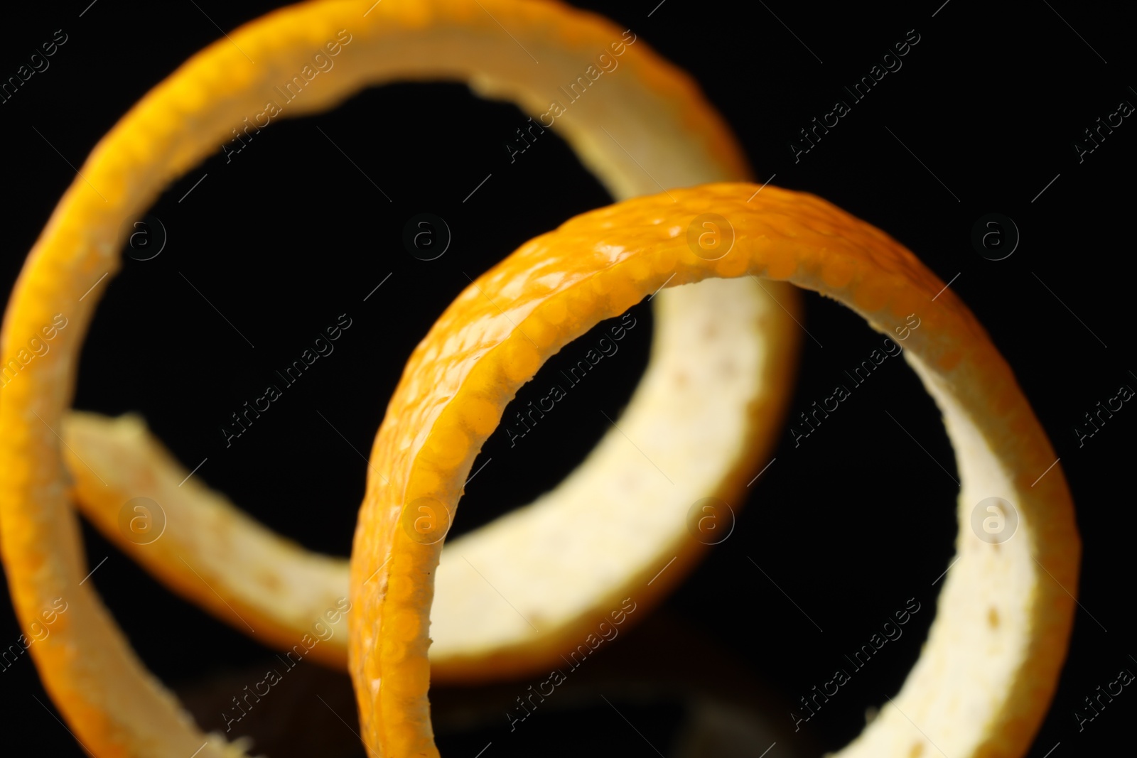 Photo of One fresh orange peel on black background, closeup