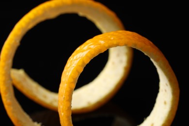 One fresh orange peel on black background, closeup